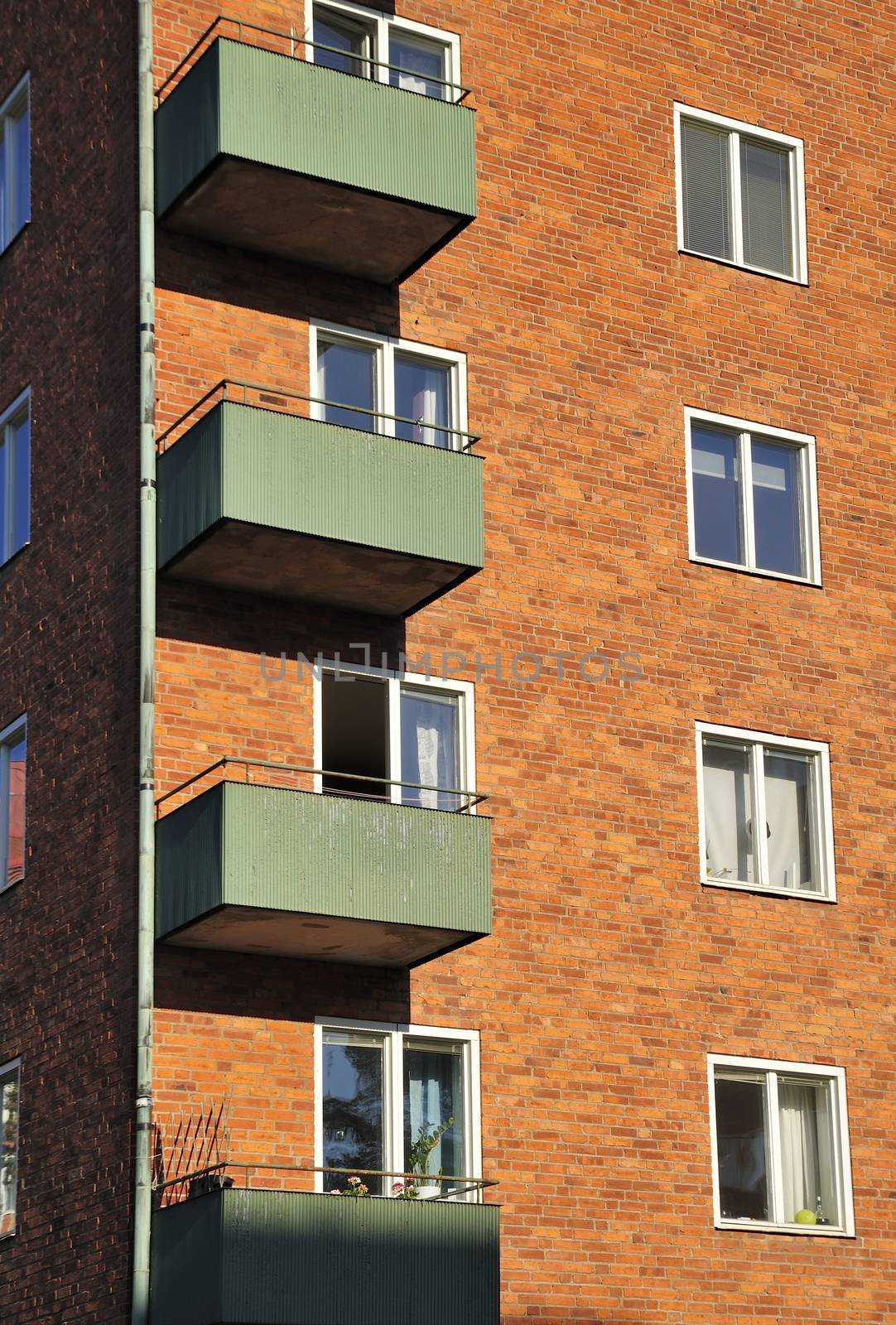 Balconies on the side of a building with many windows.