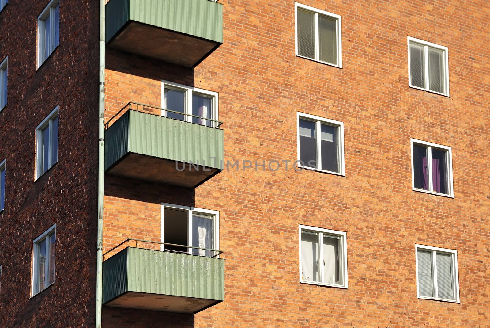 Balconies on the side of a building with many windows.