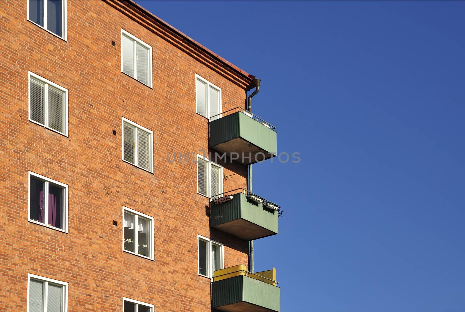 Balconies on the side of a building with many windows.