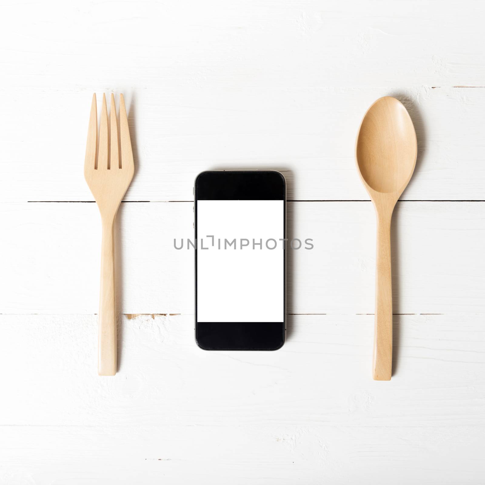 spoon and smart phone concept eating social over white table background