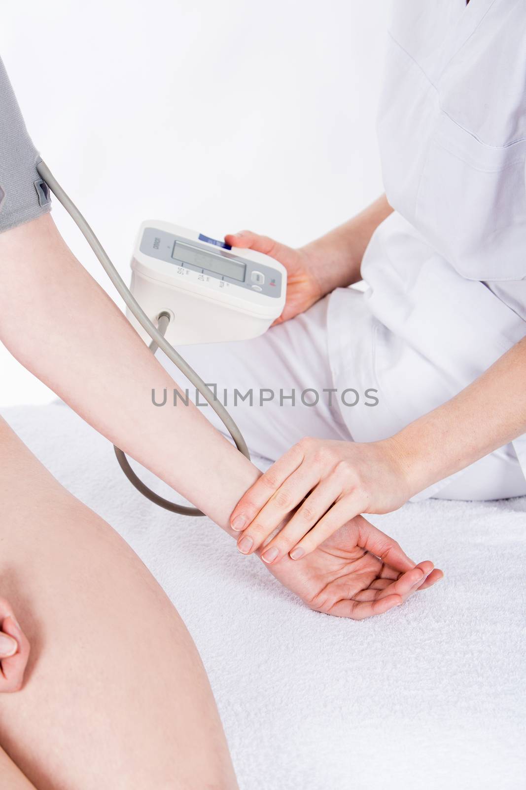 doctor gets measure the pressure to woman patient by Flareimage