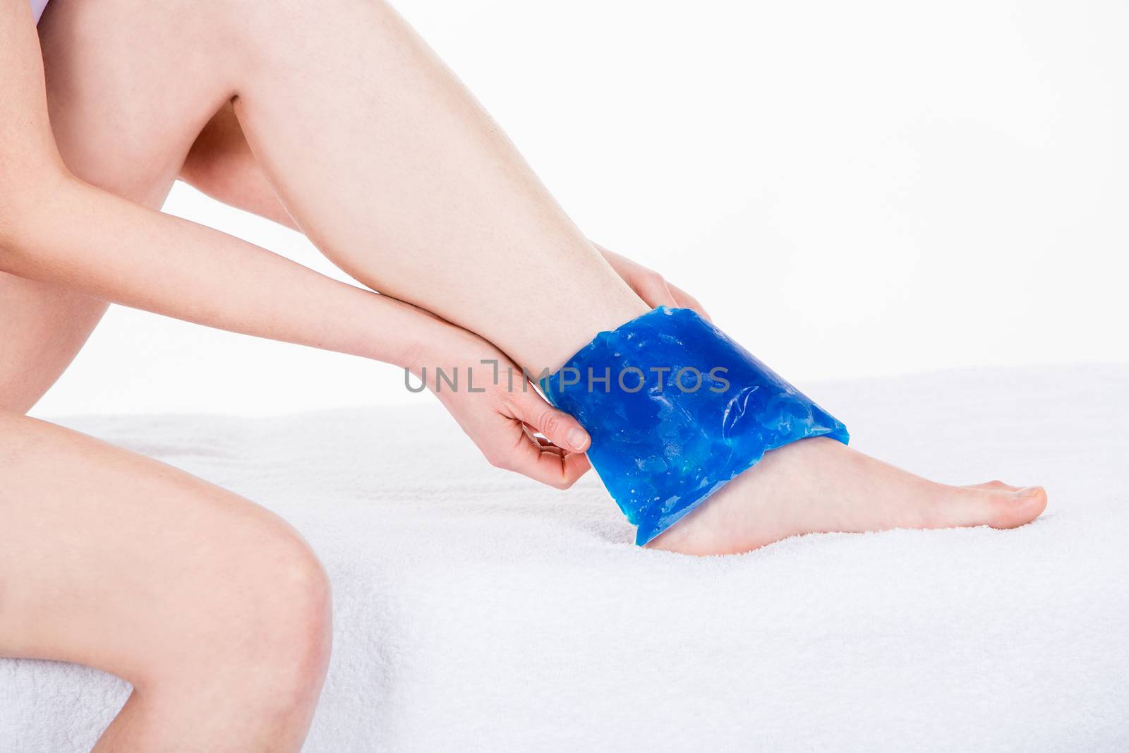 woman with ice pack on ankle  by Flareimage