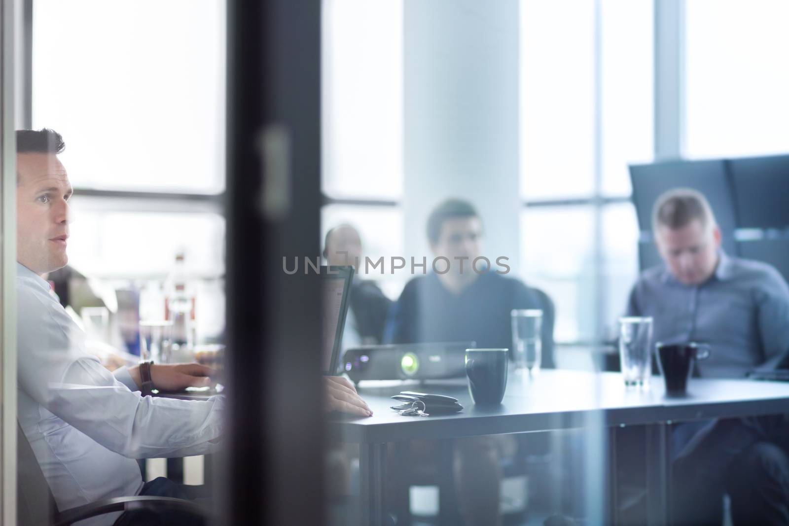 Business man making a presentation at office. Business executive delivering a presentation to his colleagues during meeting or in-house business training, explaining business plans to his employees.