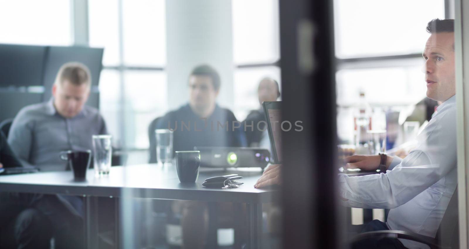 Business man making a presentation at office. Business executive delivering a presentation to his colleagues during meeting or in-house business training, explaining business plans to his employees.