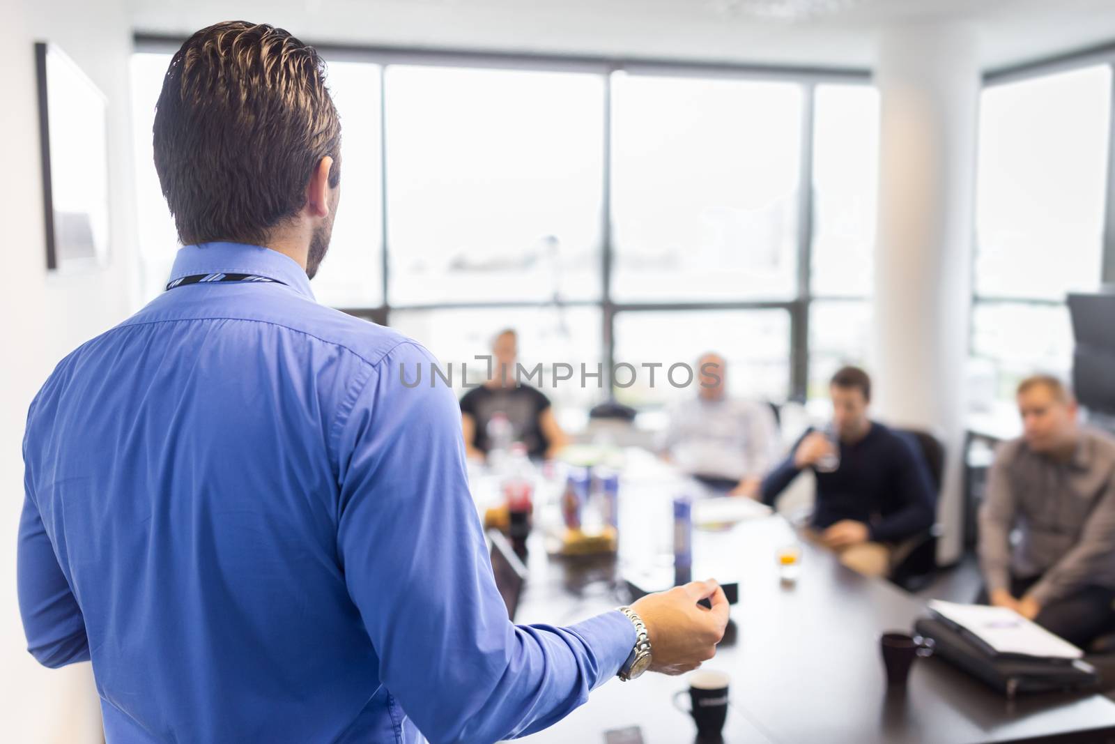 Business man making a presentation at office. Business executive delivering a presentation to his colleagues during meeting or in-house business training, explaining business plans to his employees. 