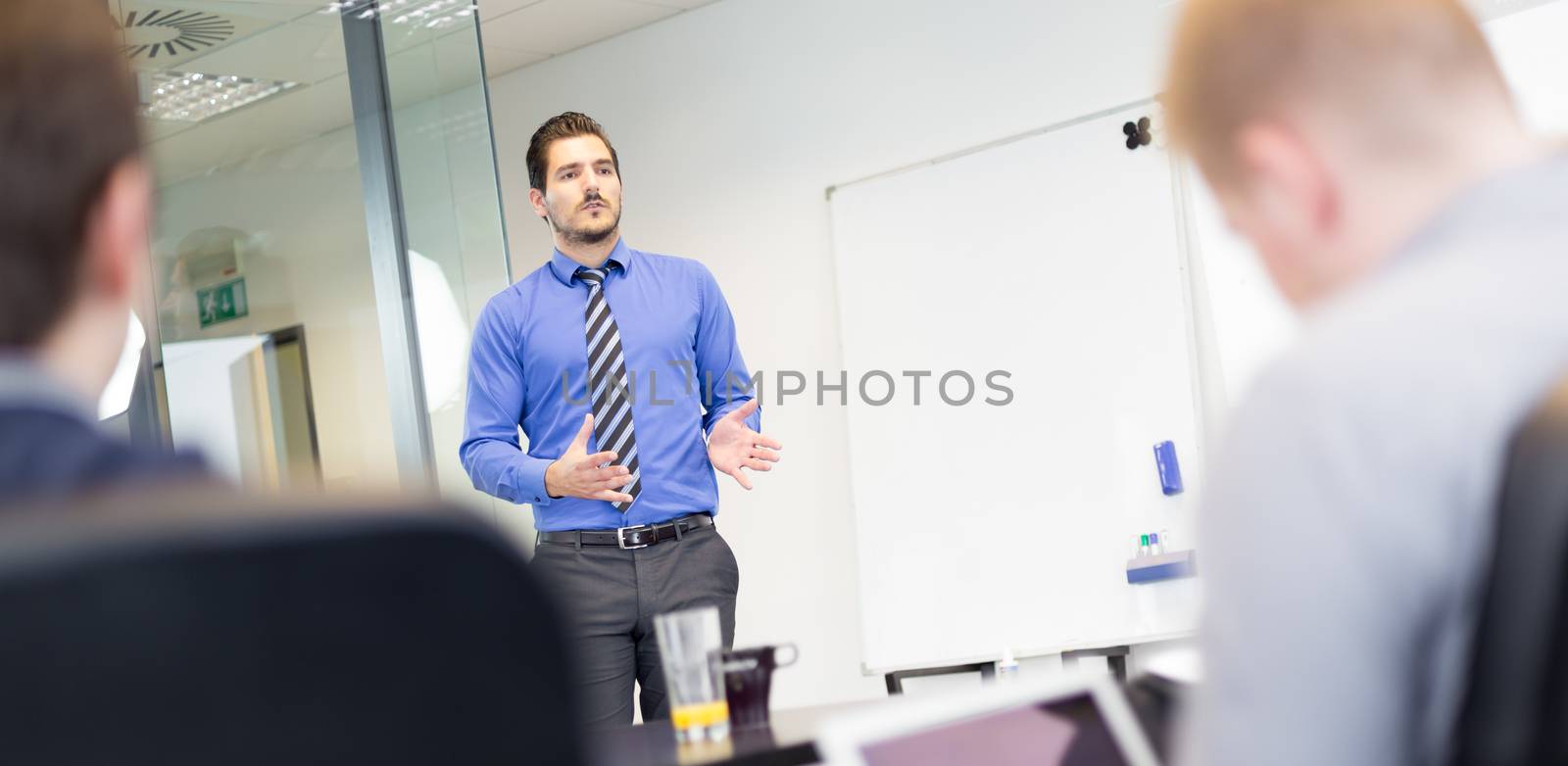 Workplace in modern office with business people brainstorming. Businessman working on laptop during the meeting. Panoramic composition.