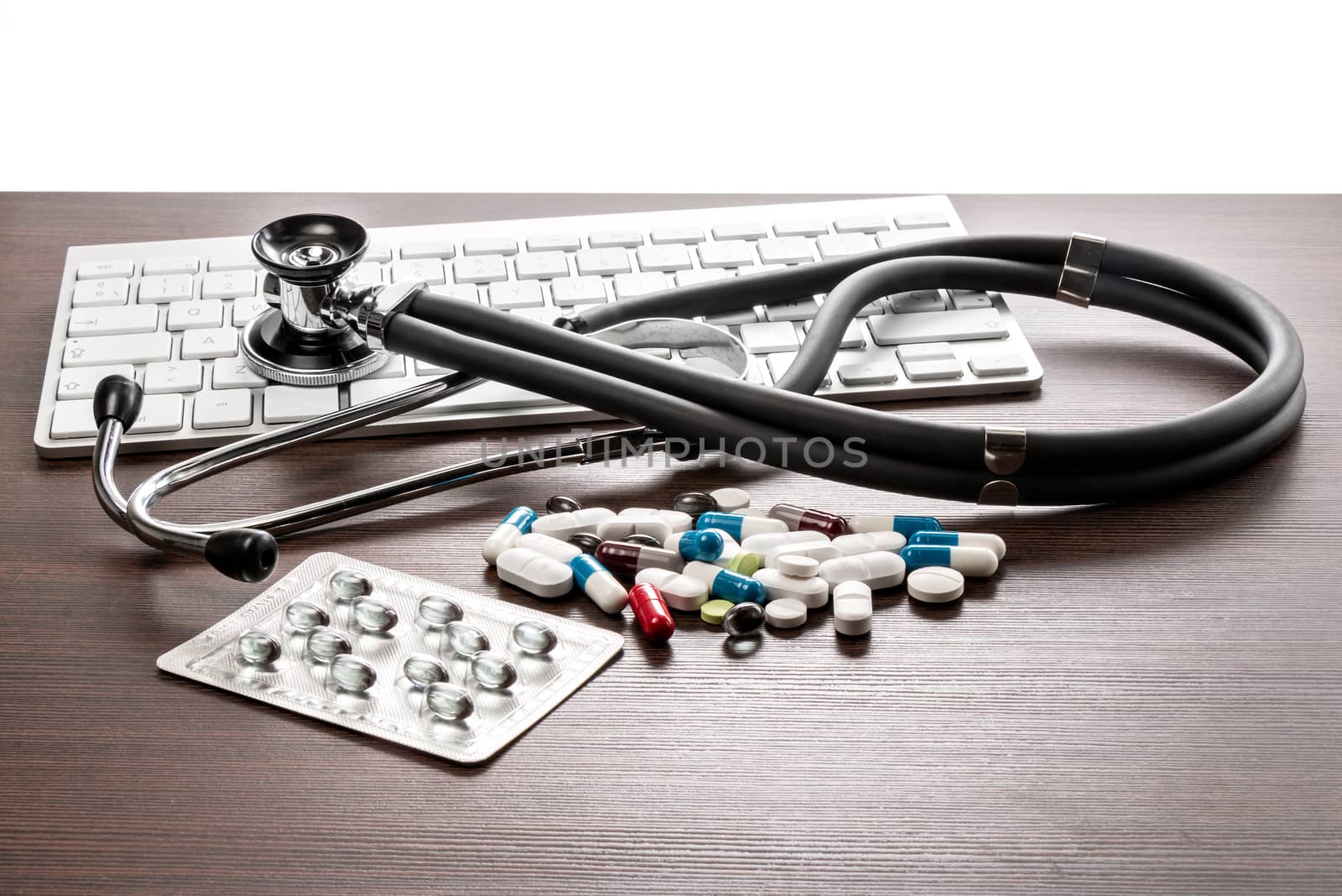 A Sthetoskop and medicines are on a brown desk