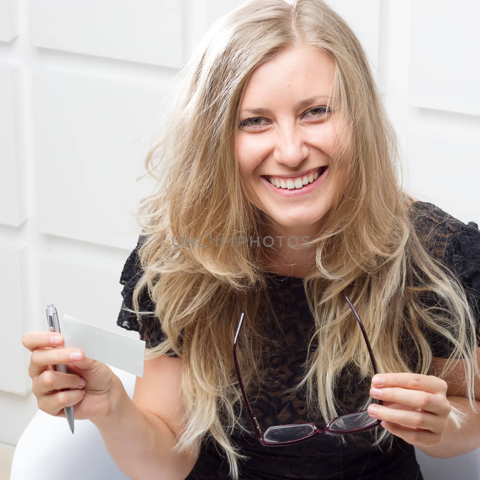 Smiling woman with glasses and a pen