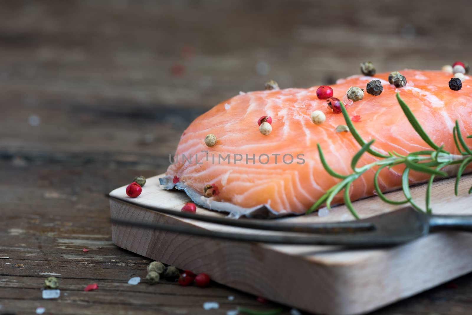 Raw Salmon Fish Fillet with Fresh Herbs on Cutting Board ready to Cook