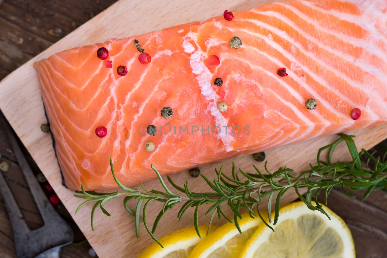 Raw Salmon Fish Fillet with Lemon, Spices and Fresh Herbs on Cutting Board