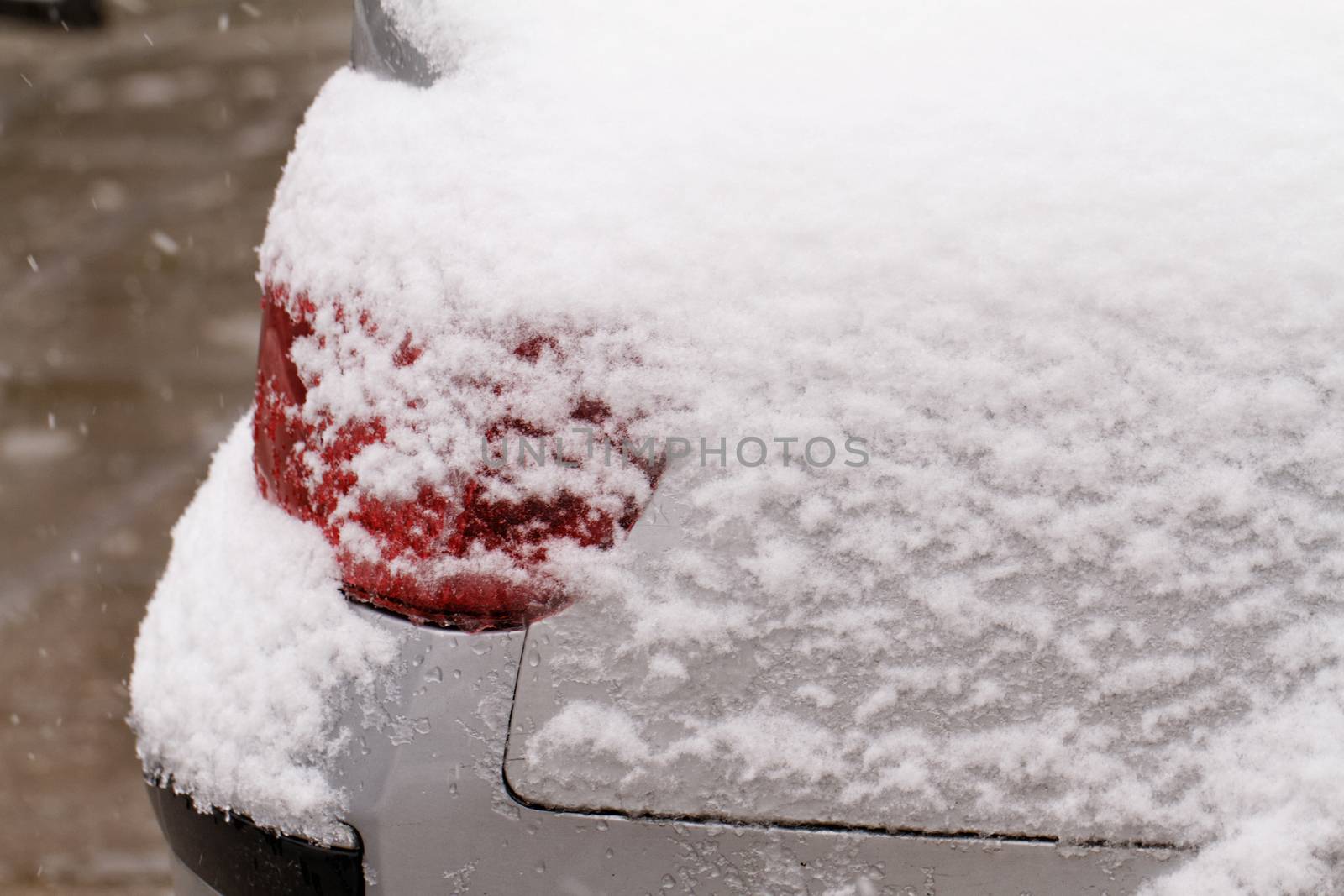 Photo of a snowy car's snowy headlight 