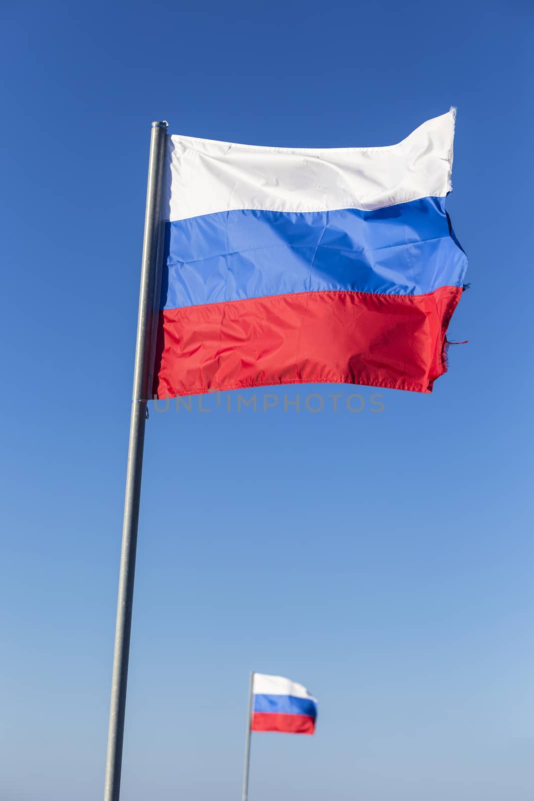 Russian flag, growing in the wind with blue sky as background