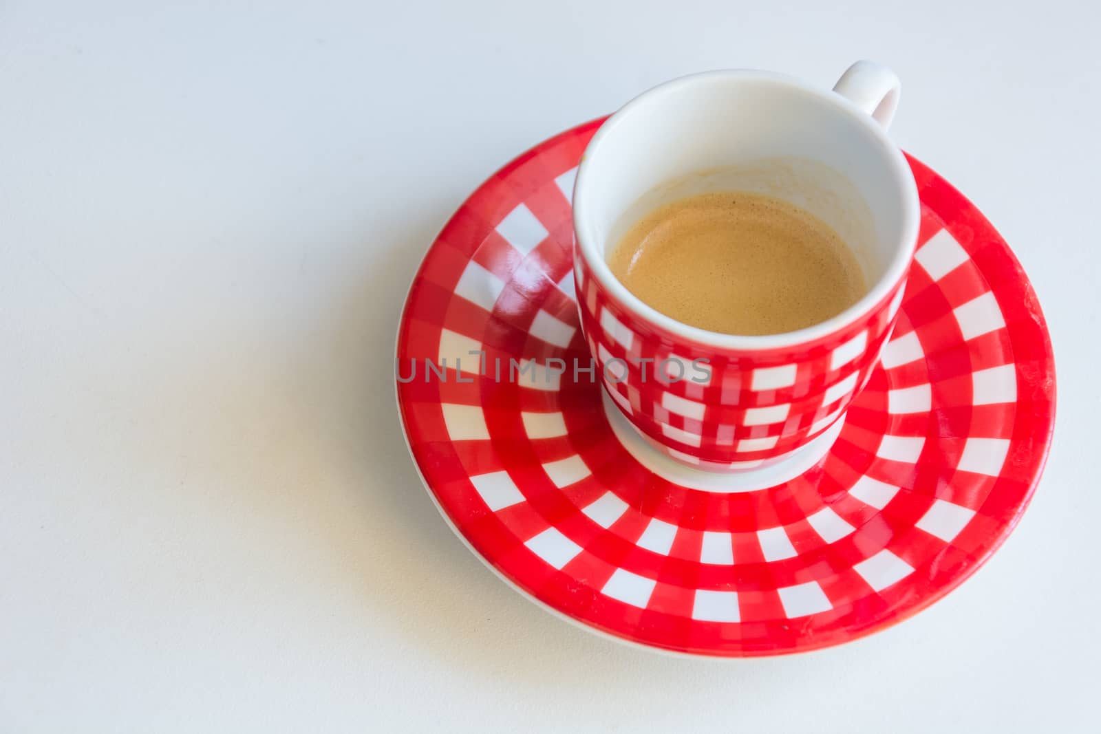 Red striped cup of coffee on a white table