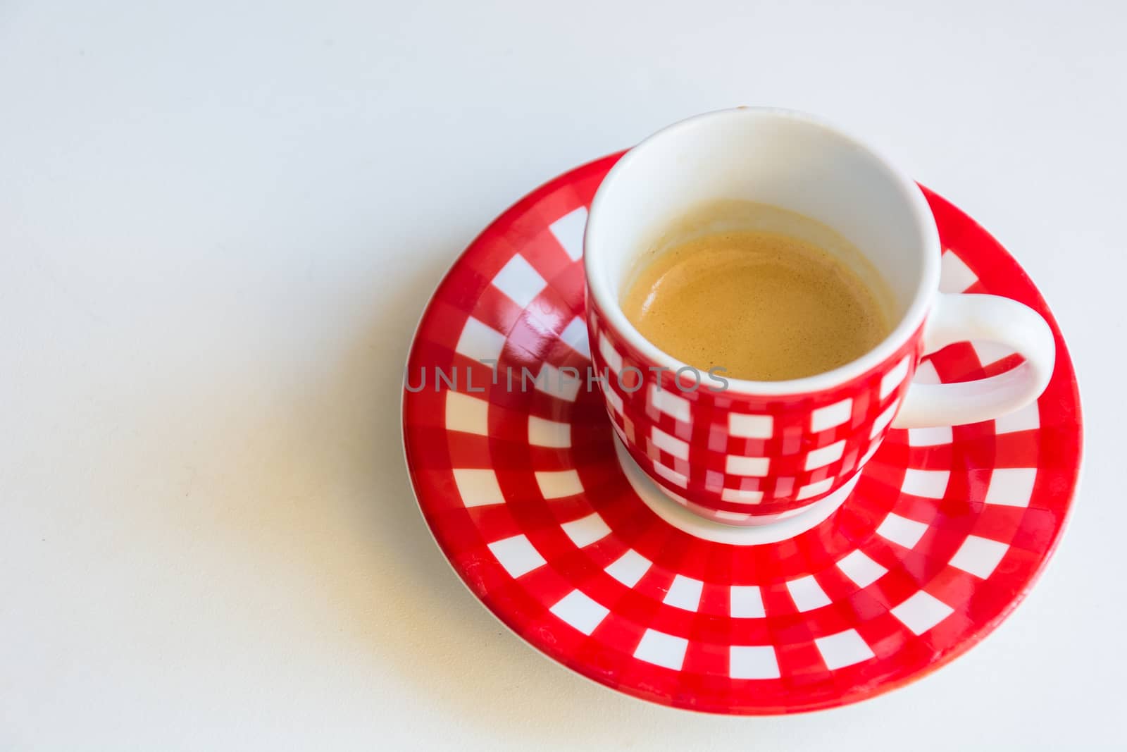 Red striped cup of coffee on a white table