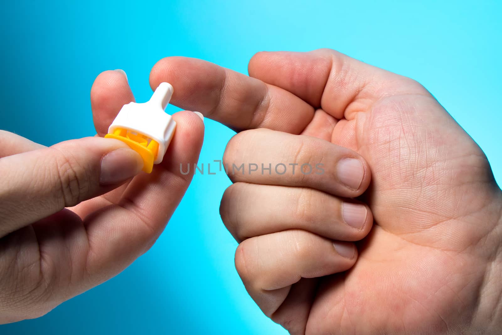 Blood test is taken at the finger, against a blue background