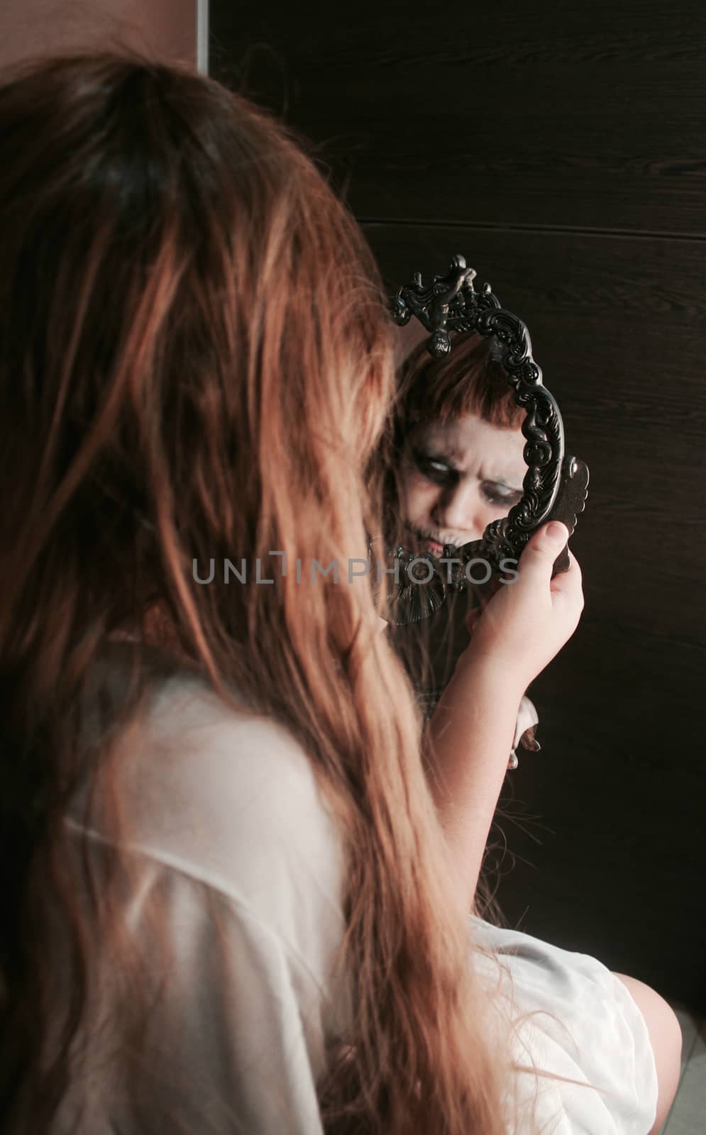 a girl staring at the mirror but her reflection is horrifying.