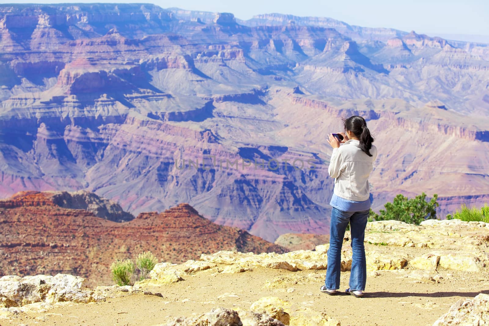 Teen girl taking pictures at the Grand Canyon by jarenwicklund