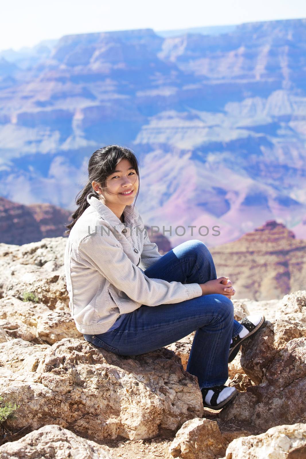 Young teen girl sitting on rocky edge at Grand Canyon by jarenwicklund