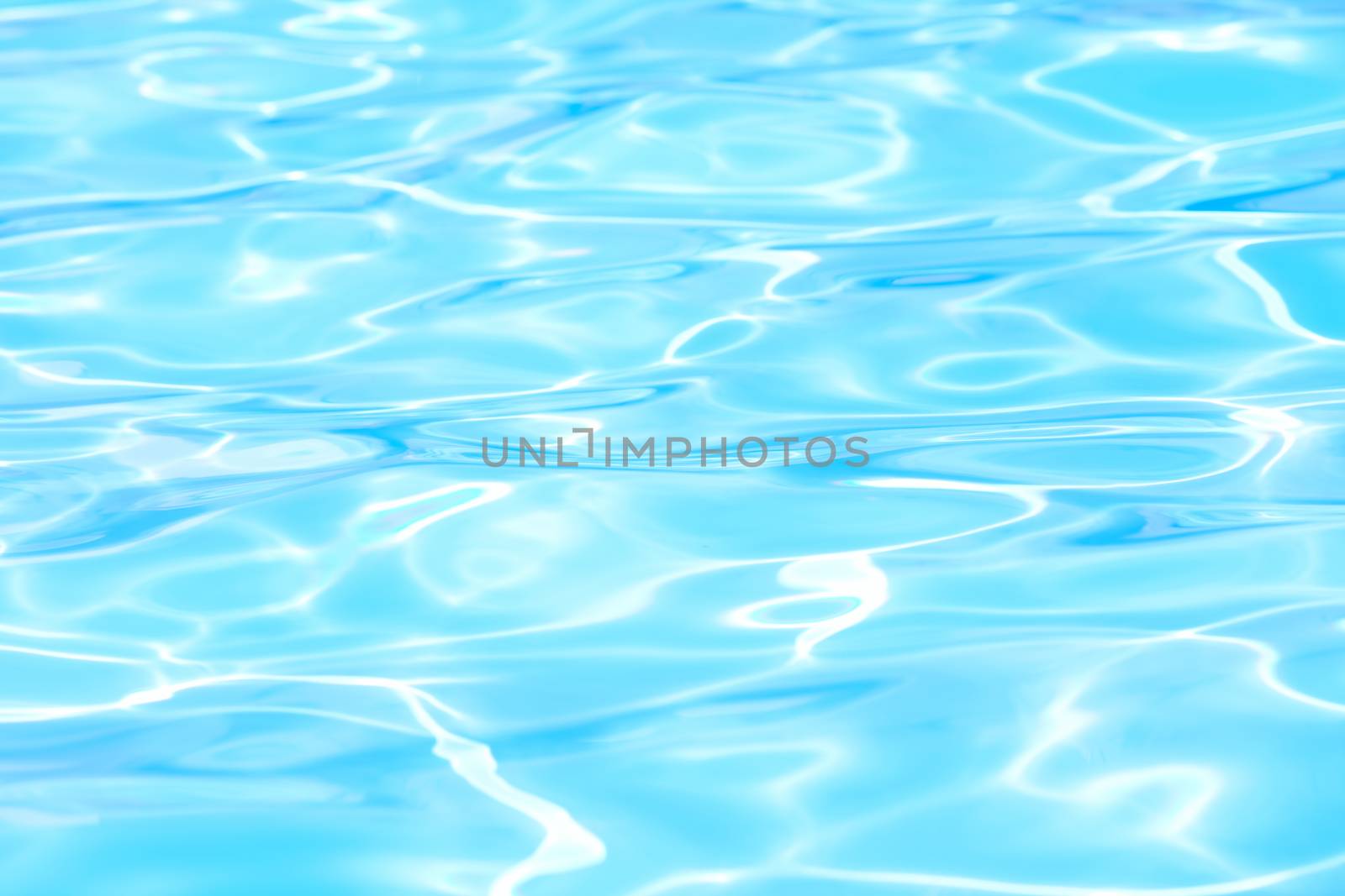 Aqua blue waves of pool water with sunlight 