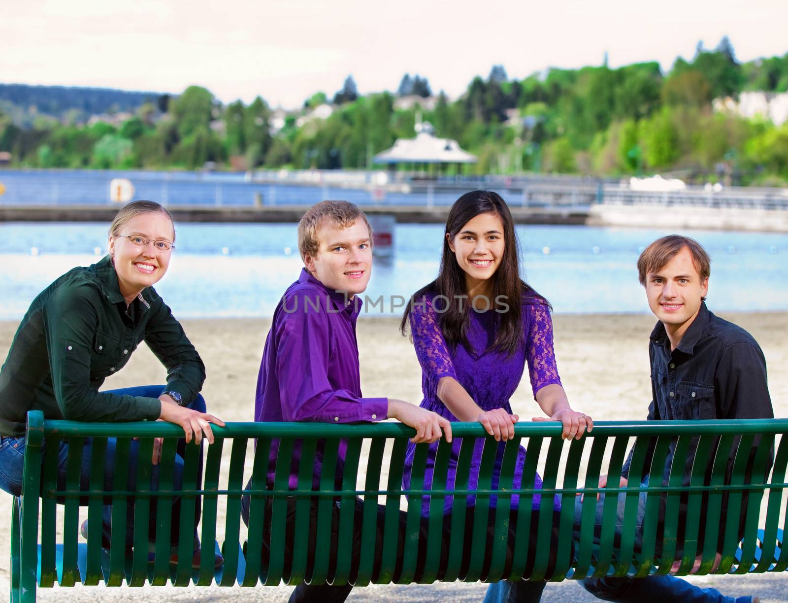 Four young multiethnic friends in early twenties  together at beach