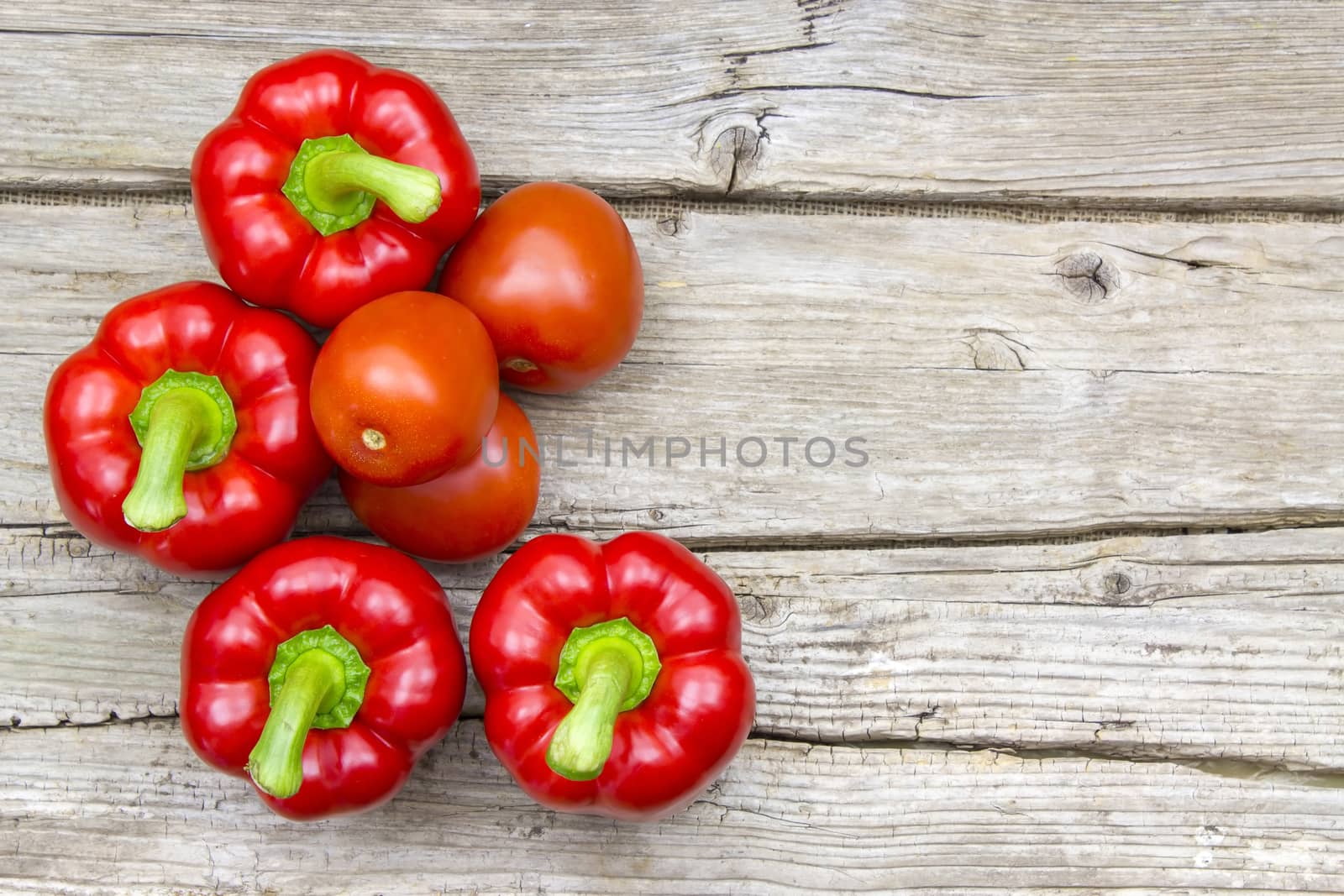 tomatoes and peppers on wooden background by miradrozdowski