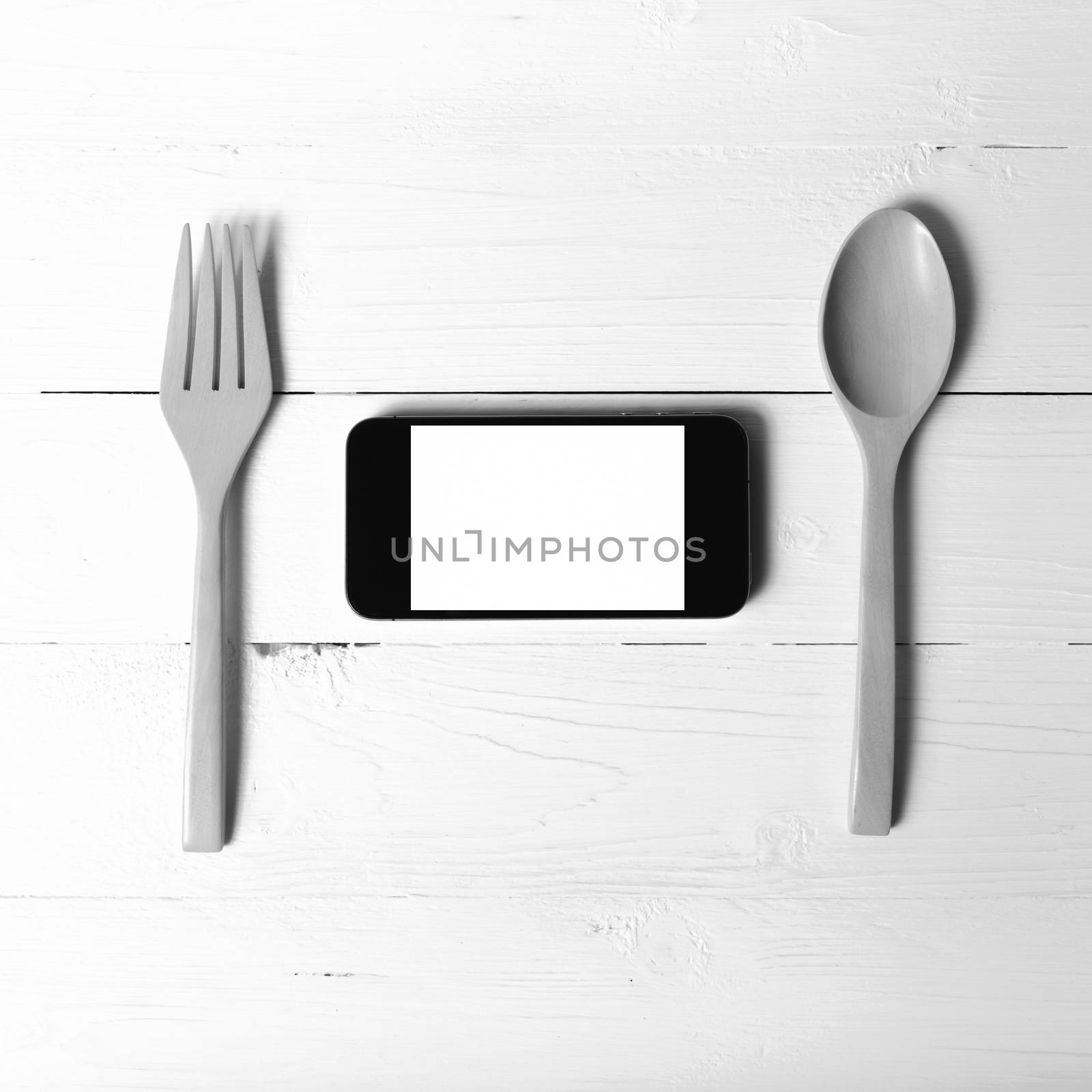 spoon and smart phone concept eating social over table background black and white tone color style