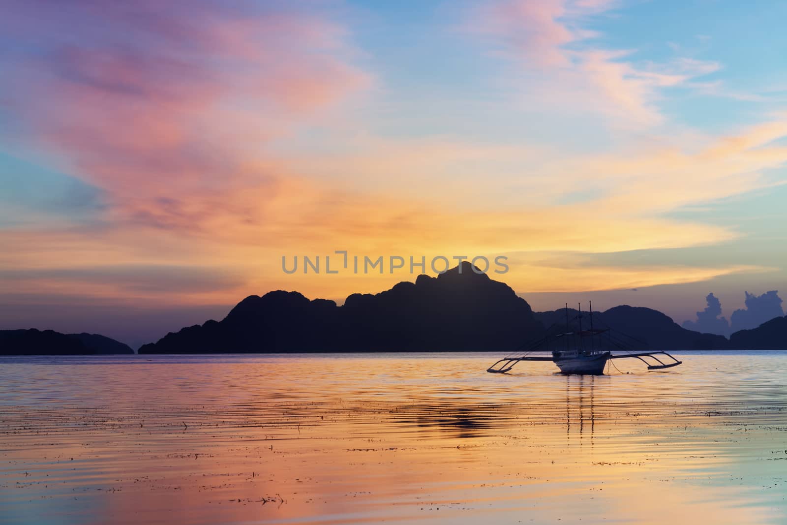 Tropical sunset with a banca boat in Palawan - Philippines