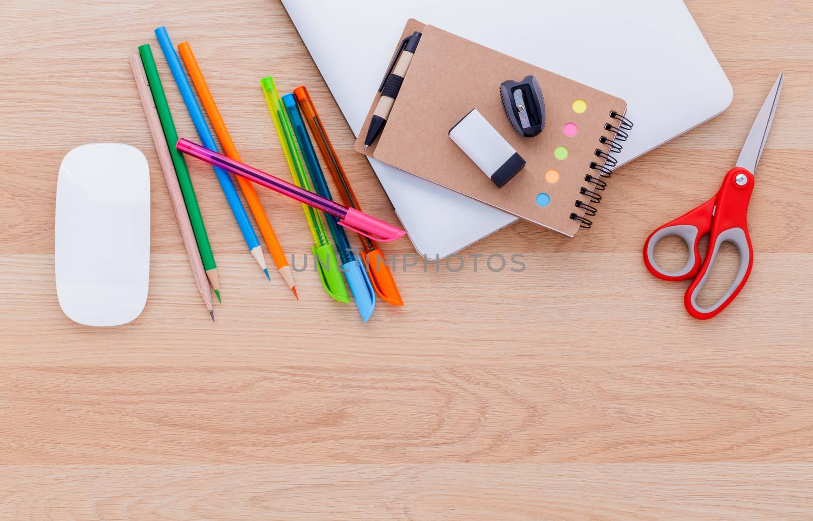 Back to school concept with school supplies laptop ,notebook, pen and colored pencil on wooden table .