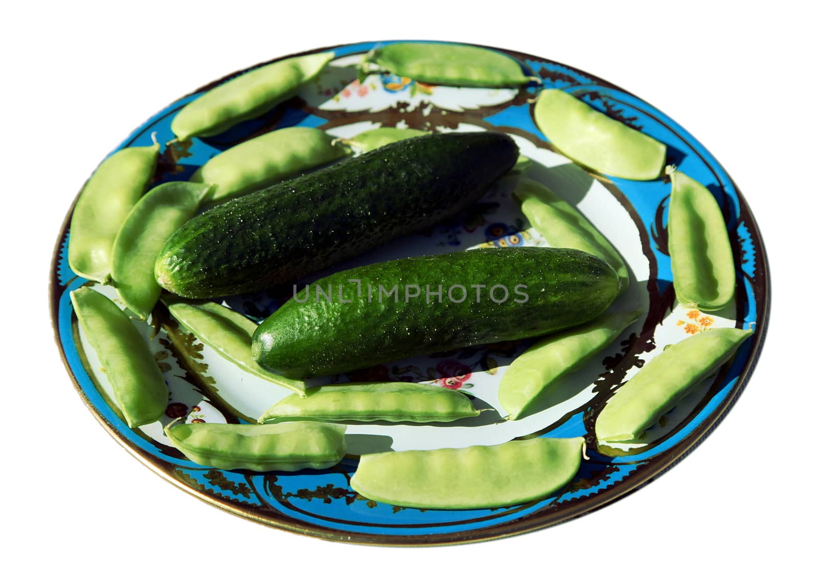 Home grown cucumbers and split peas on a plate isolated on white background