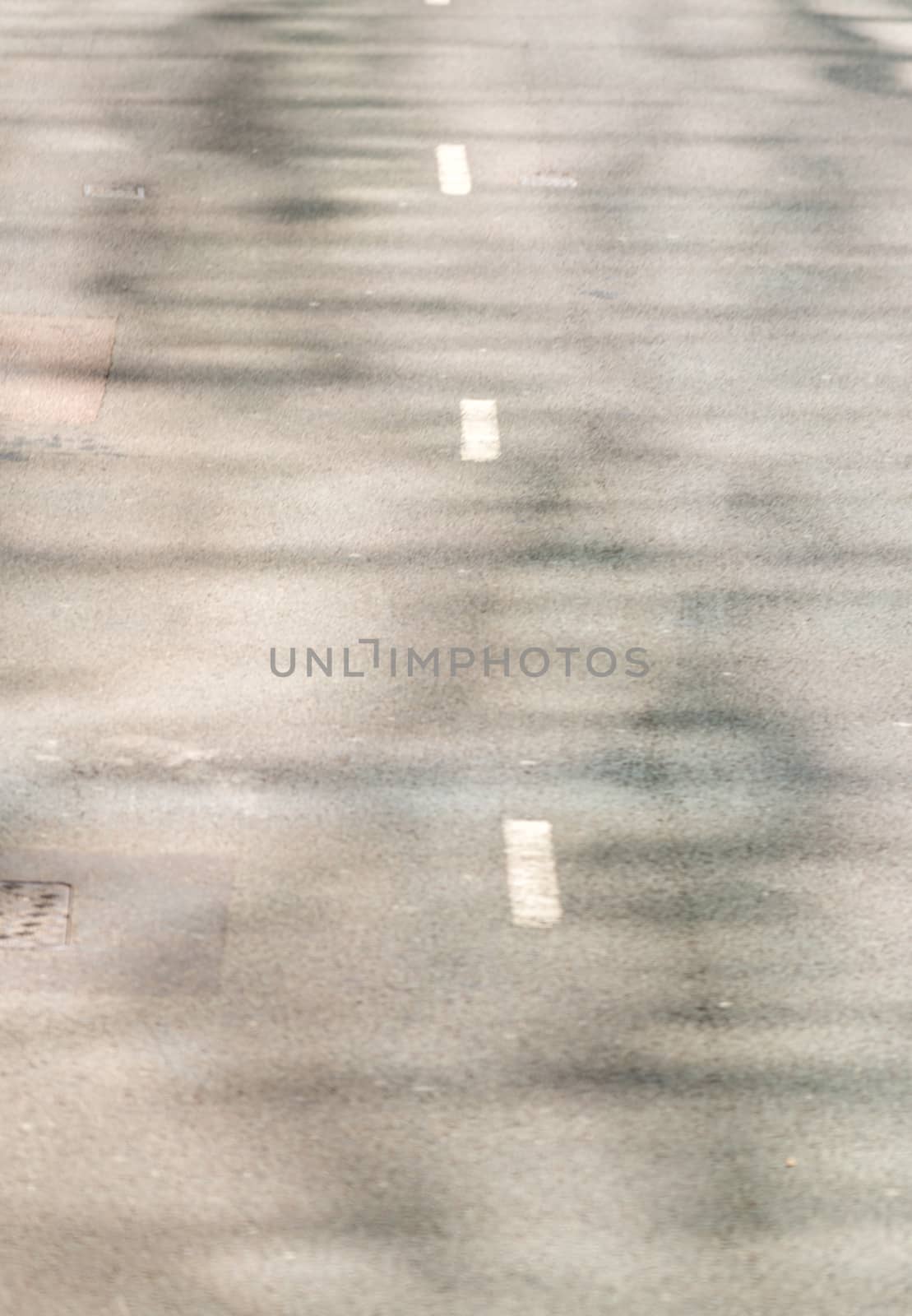 Blurred view of white lines in the middle of a road by jovannig