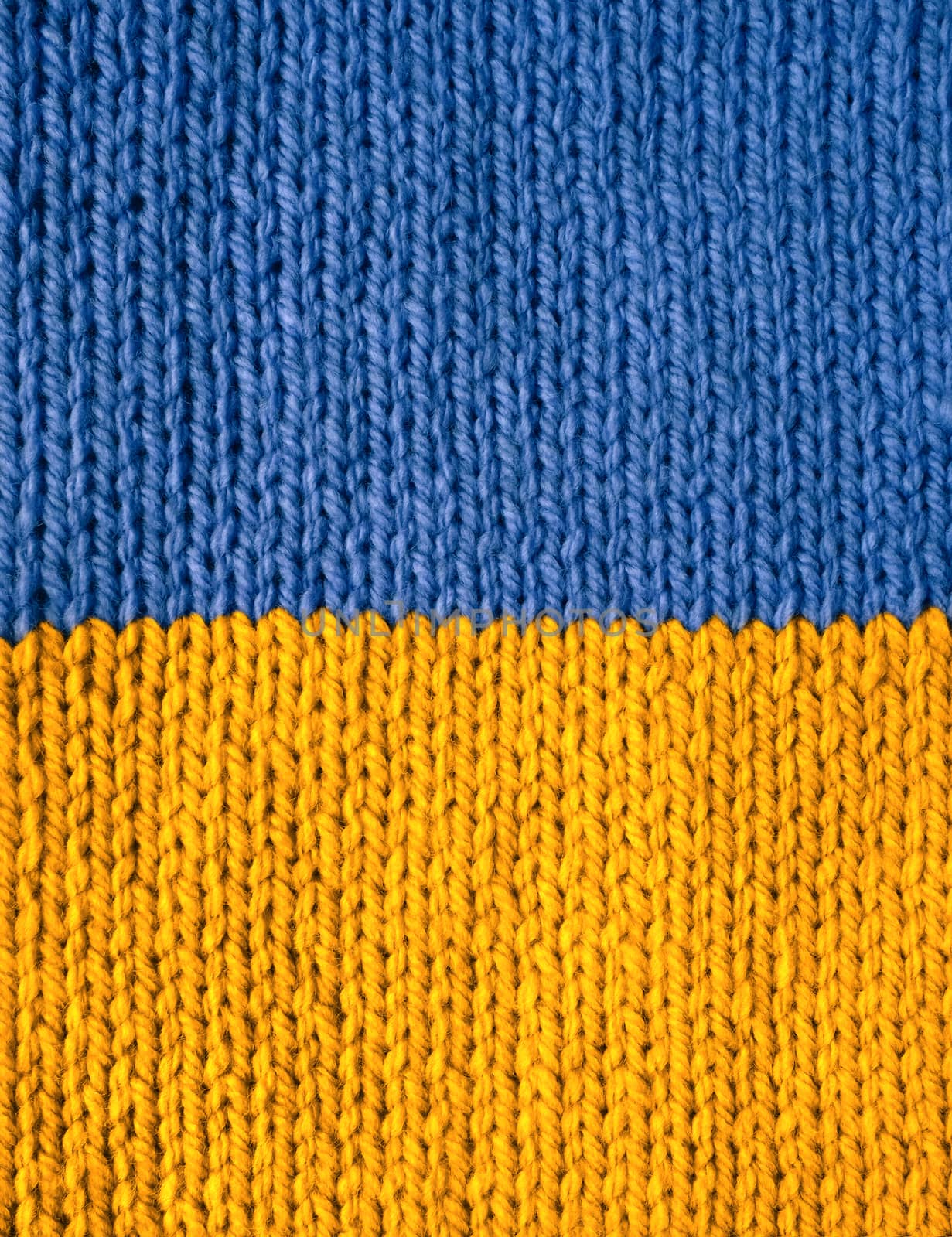 Stockinette stitch knitting in blue and yellow wool as an abstract background texture