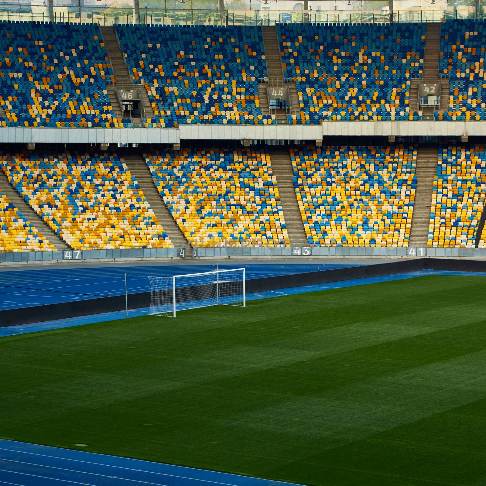 Huge Empty Football Arena, seats are painted a yellow and a blue