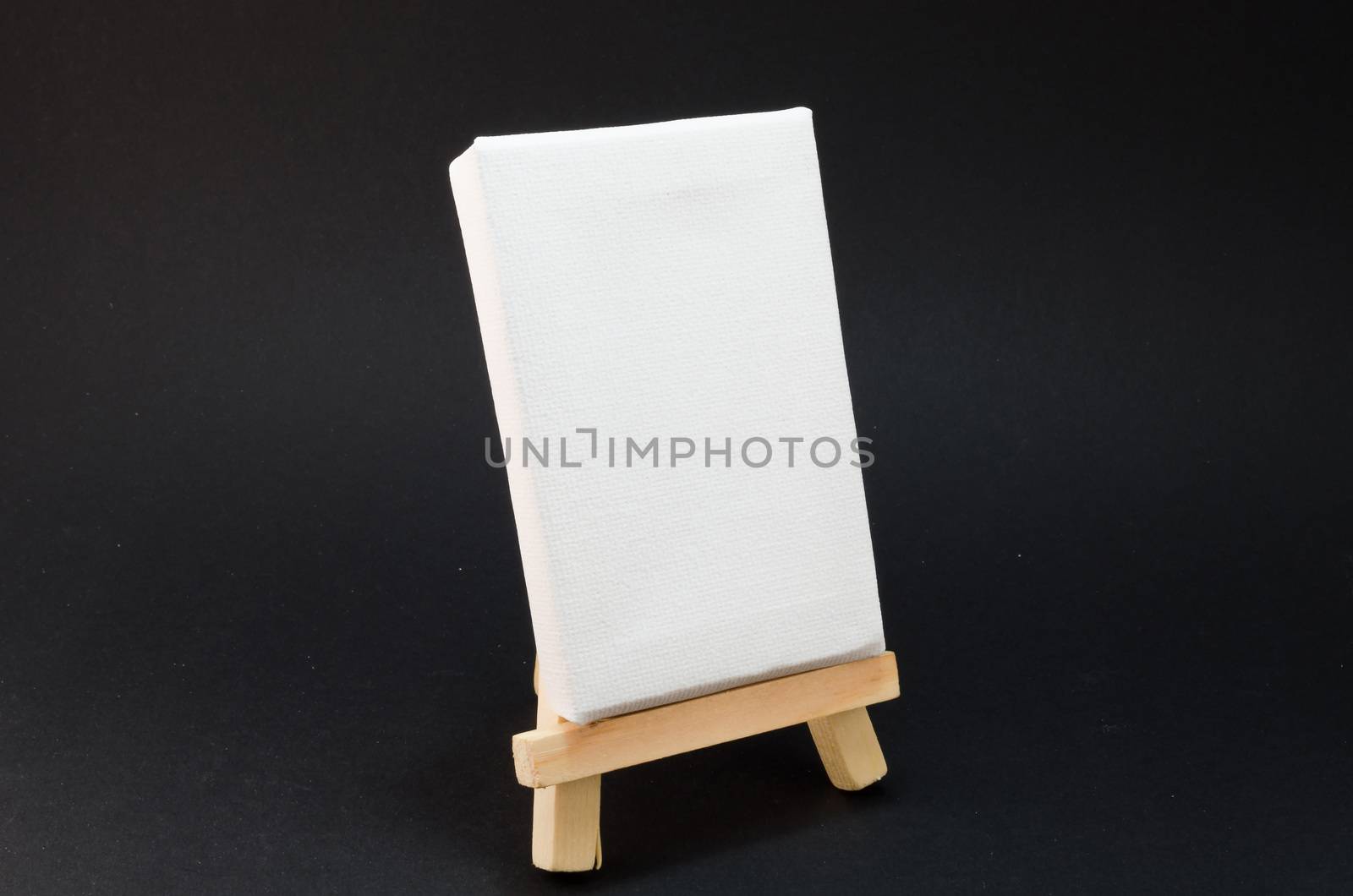 Miniature artist easel, isolated against a black background.