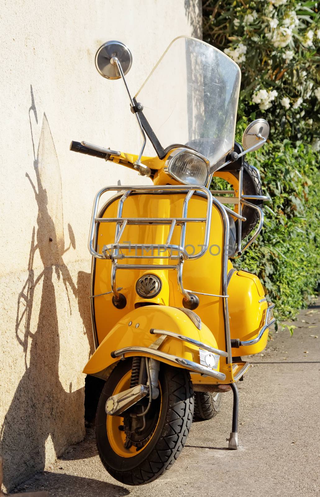 yellow retro motorcycle standing against wall