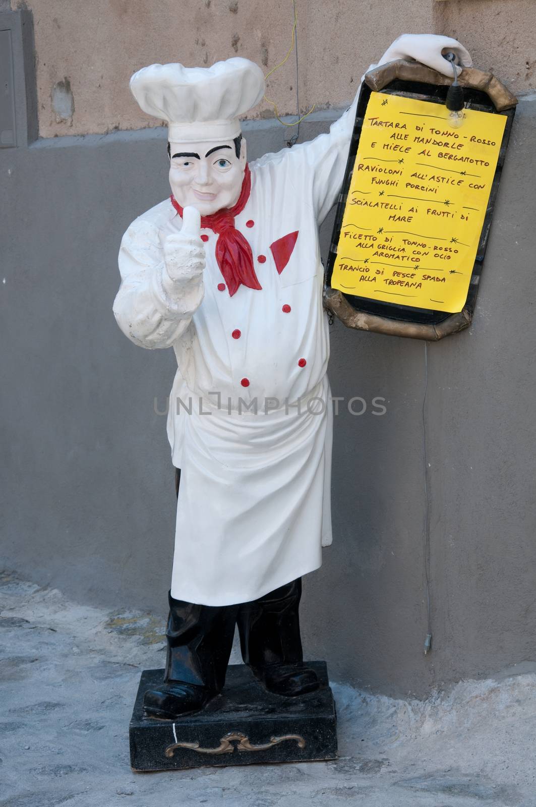 Statue of chef holding a menu of a restaurant