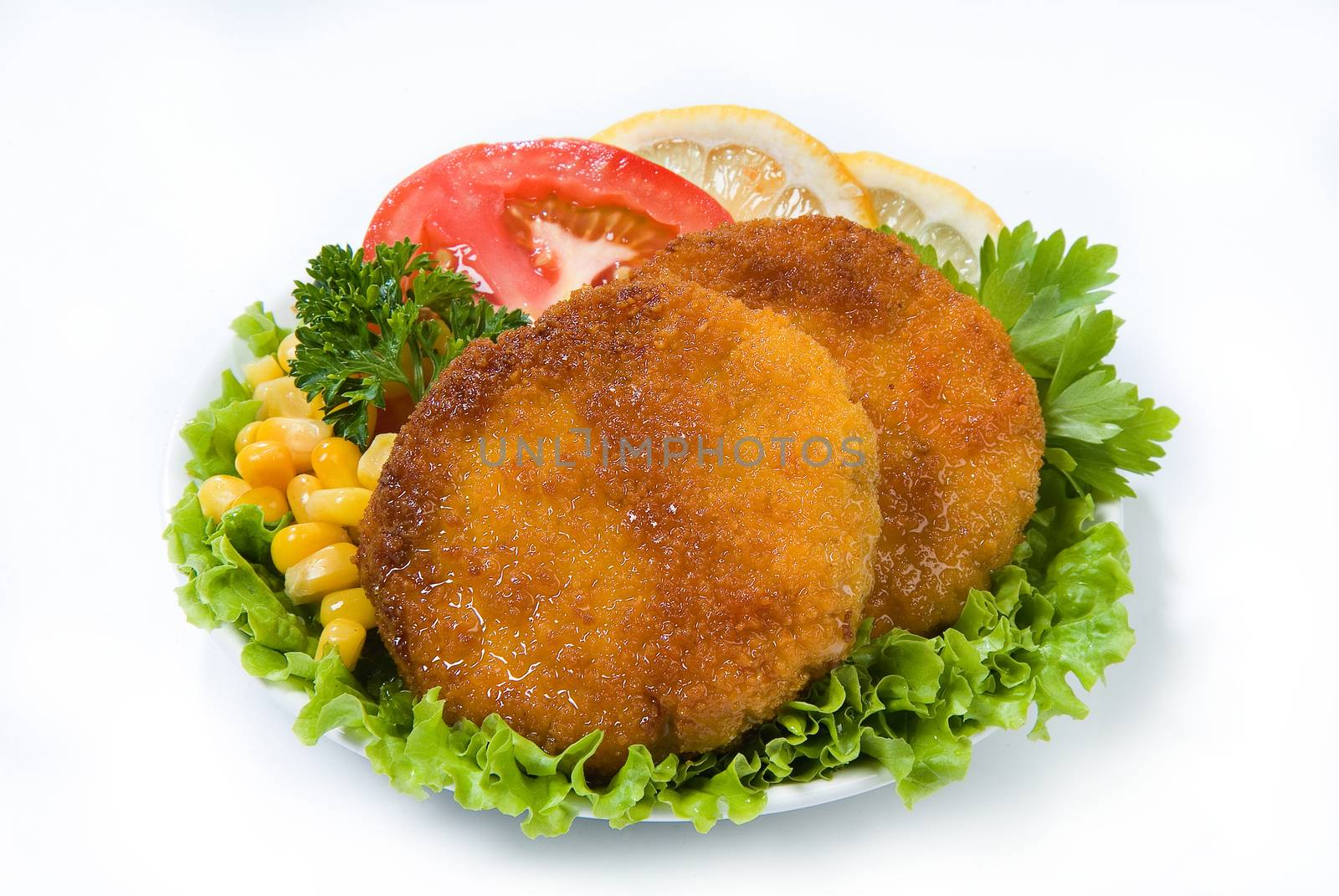 Cutlets with greenery, lemon, tomatoes and peas