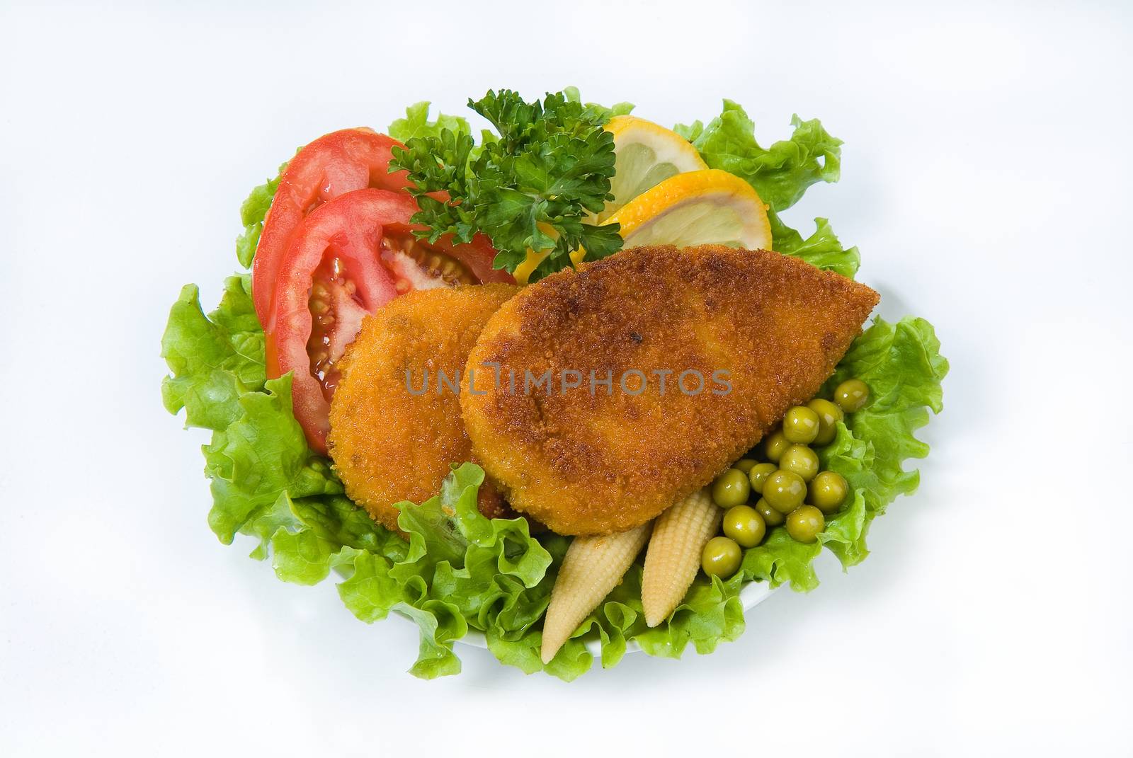 Cutlets with greenery, lemon, tomatoes and peas