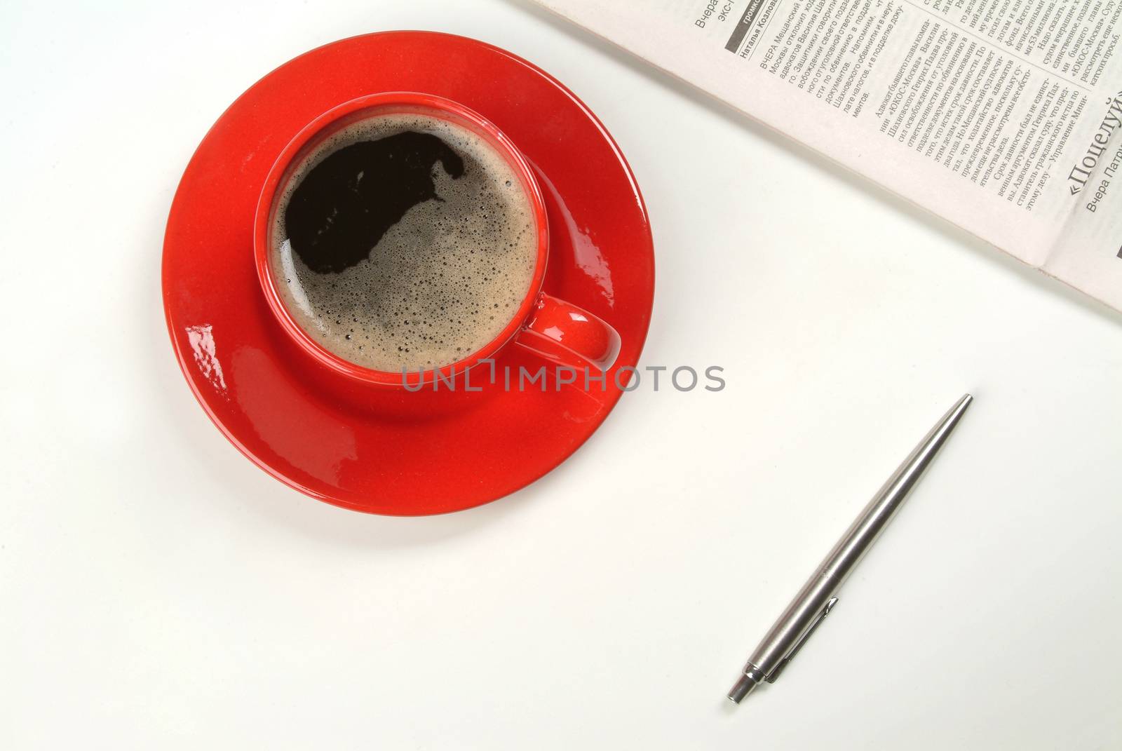 Cup of coffee, pen and newspaper on isolated studio background