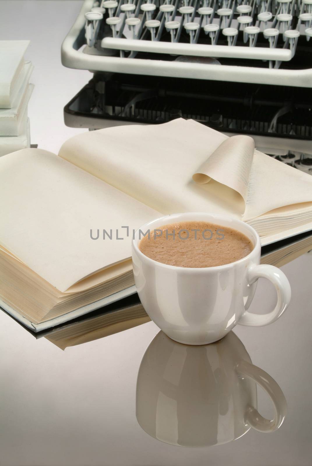 Cup of coffee an old typewriter on a glass background