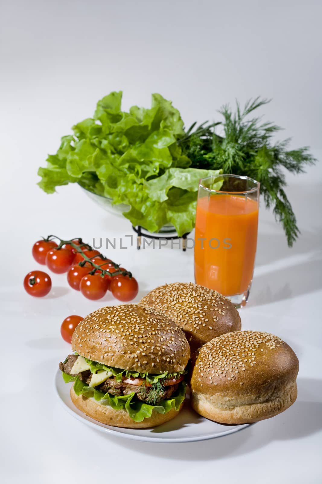 Hamburgers, greenery, tomatoes and juice
