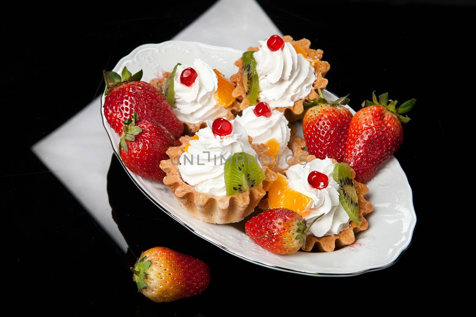 Strawberries and whipped cream on a black glass background