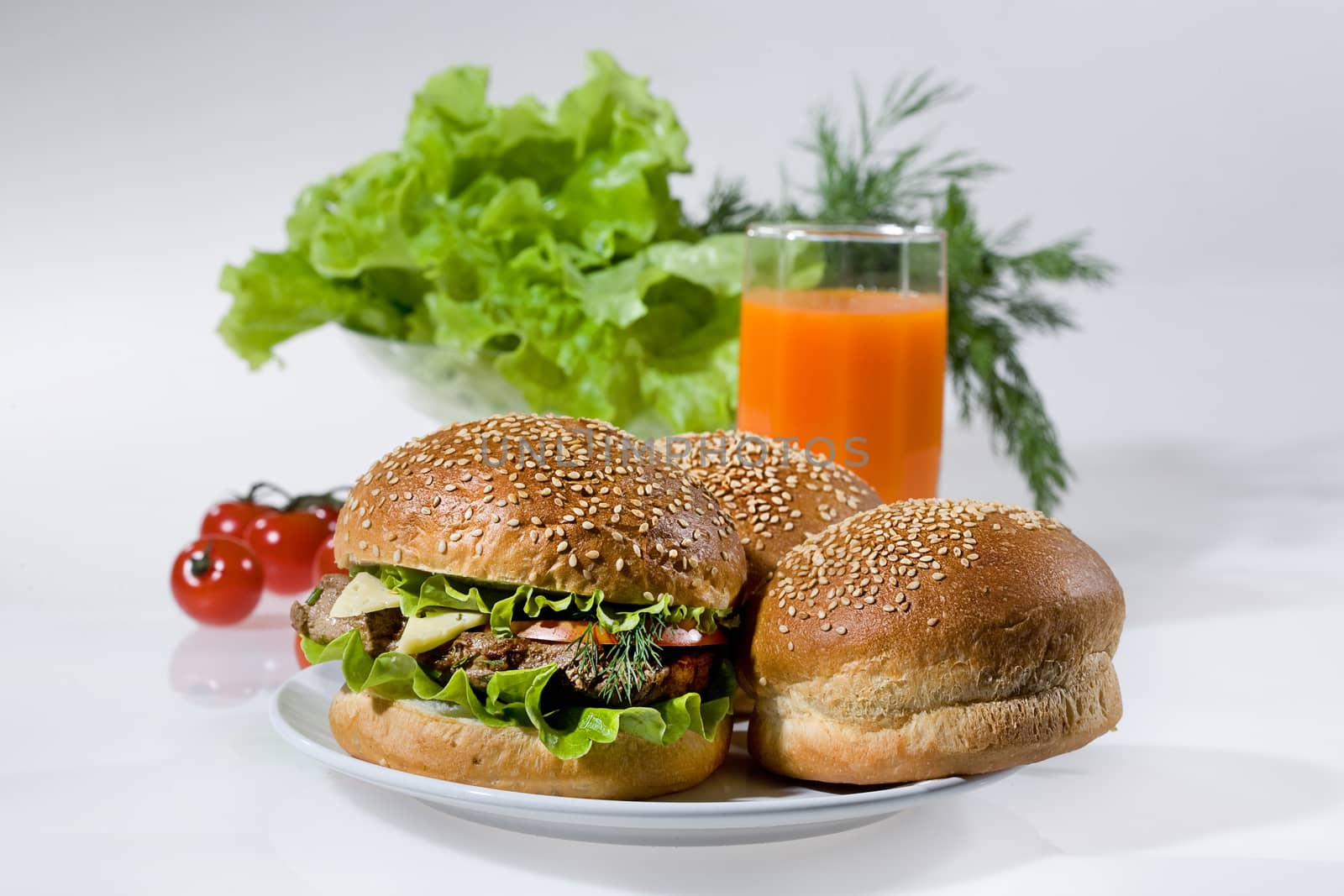 Hamburgers, greenery, tomatoes and juice