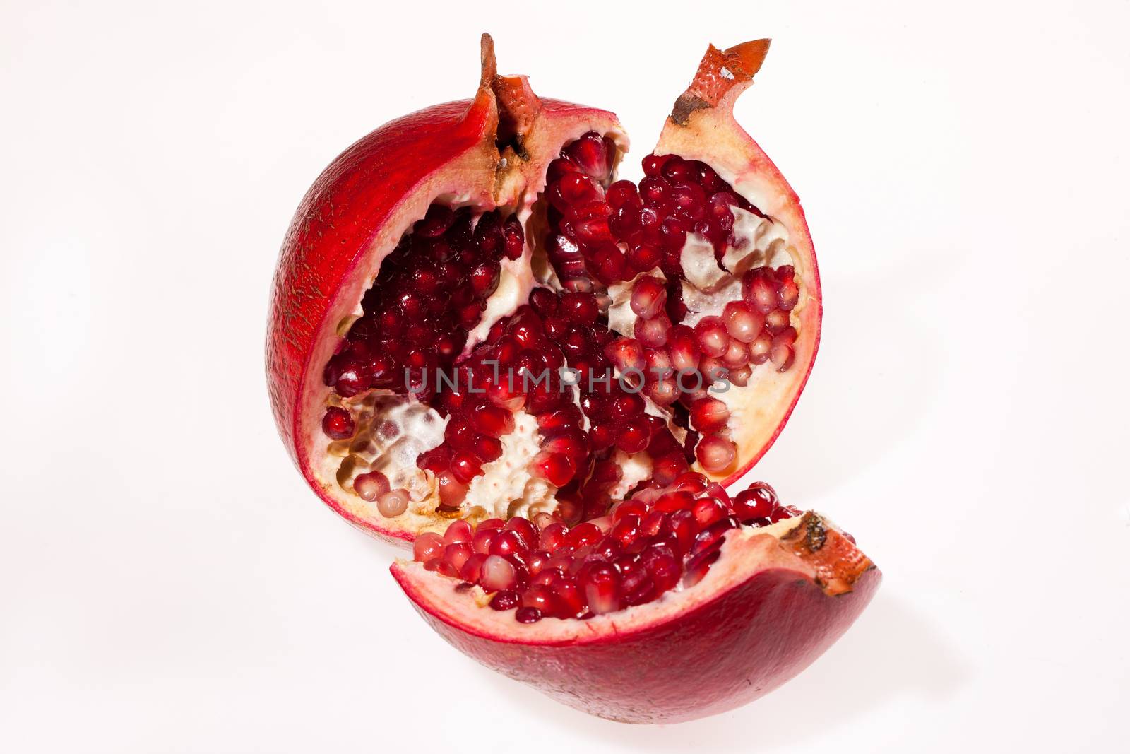 Crashed pomegranate on isolated studio background