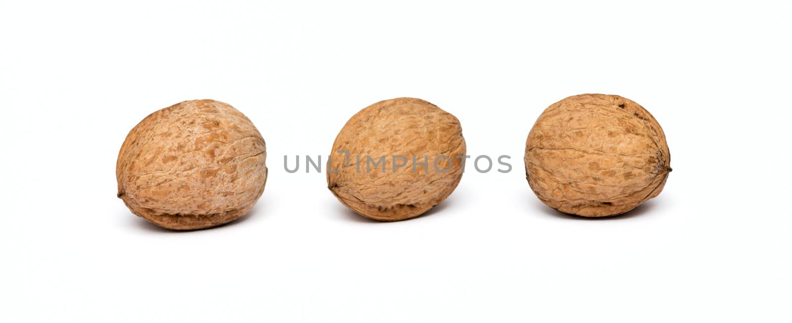 three walnuts close up isolated on white background by DNKSTUDIO