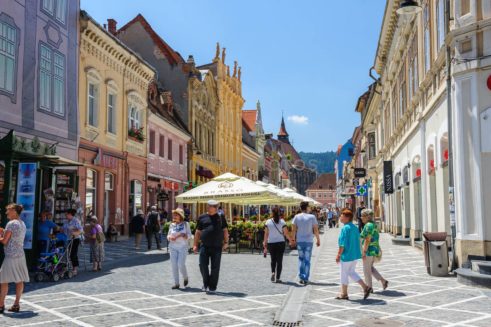 Brasov, Transylvania, Romania, 6th July 2015: Republic street is par of pedestrian area in historical center of city, people walkinng and sitting at outdoor terraces and restaurants.