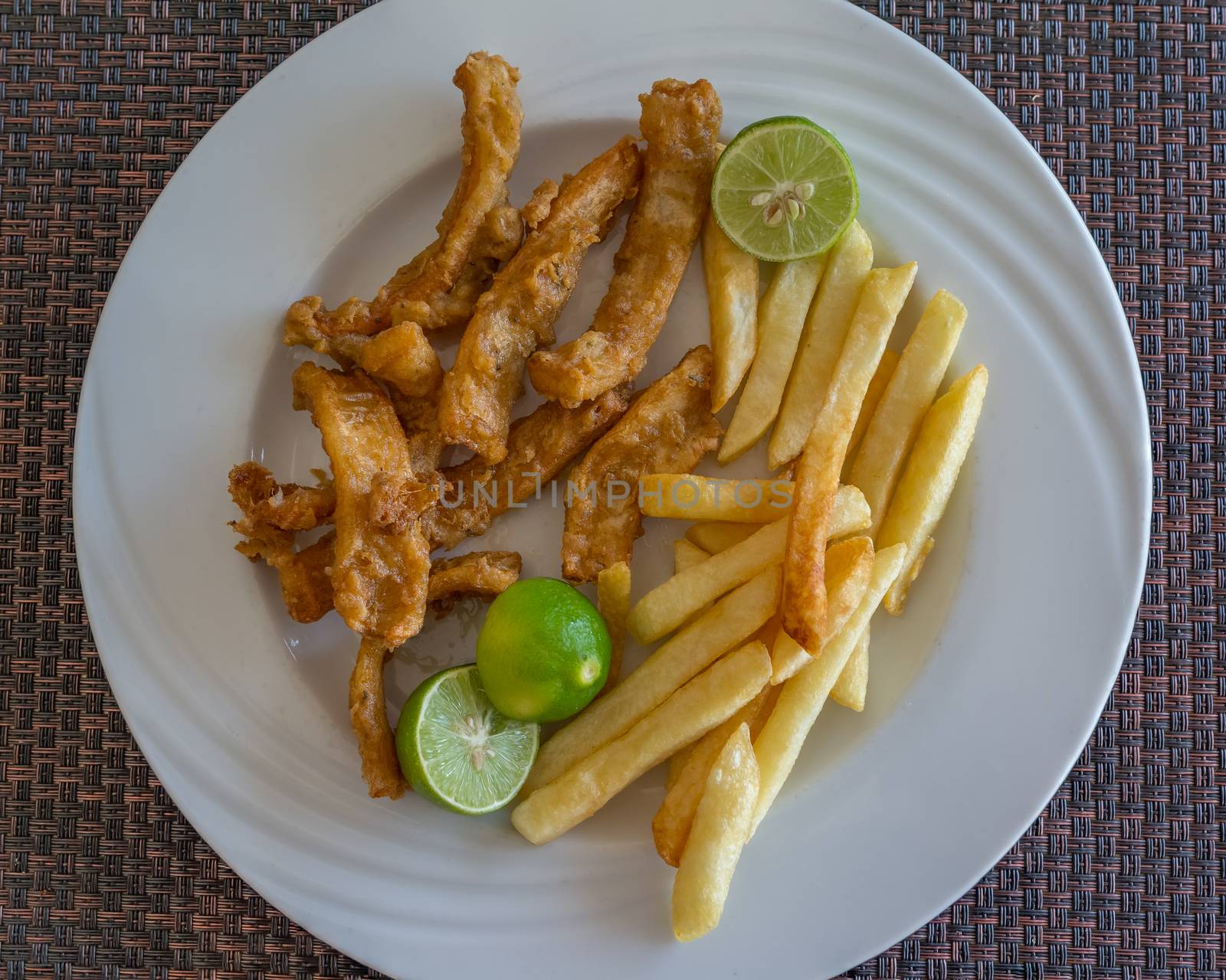 In the photo fried calamari served with fries and three lime as a garnish
