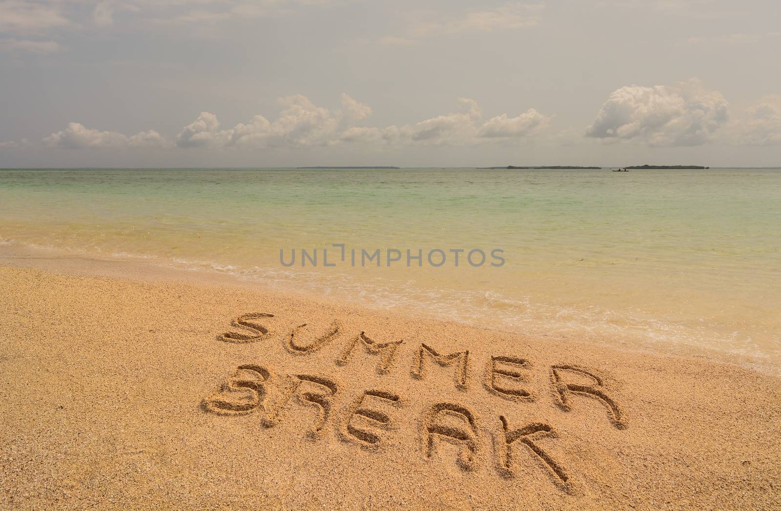In the photo a beach in Zanzibar in the afternoon where there is an inscription on the sand "Summer Break".