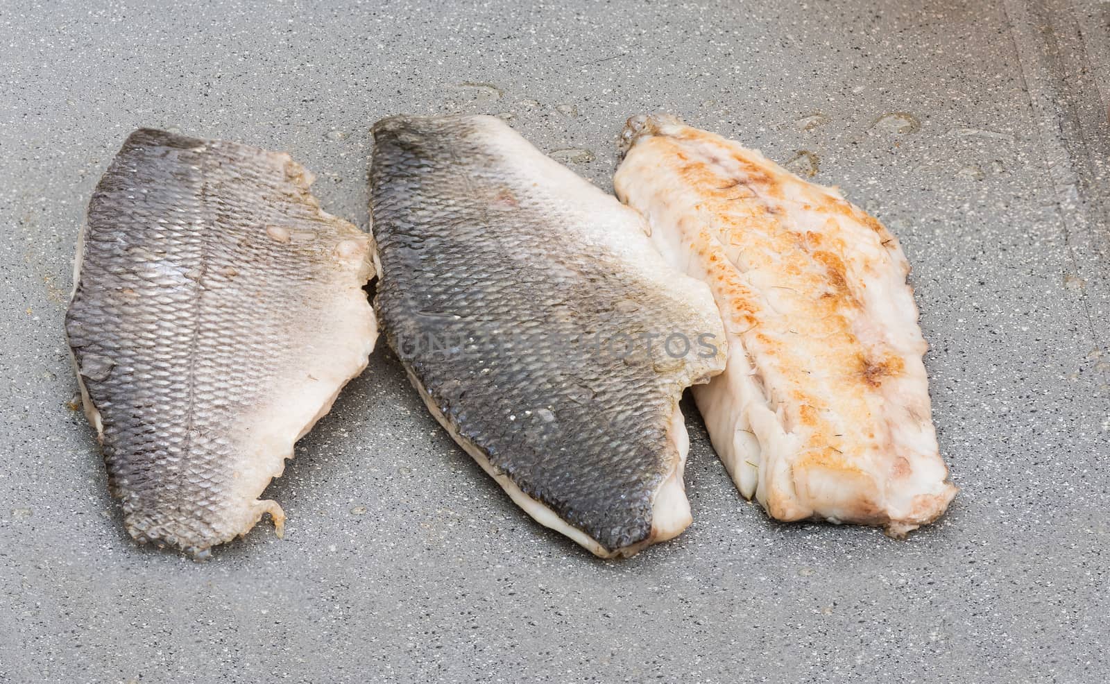 Pictured three fillets of sea bream cooked on the grill