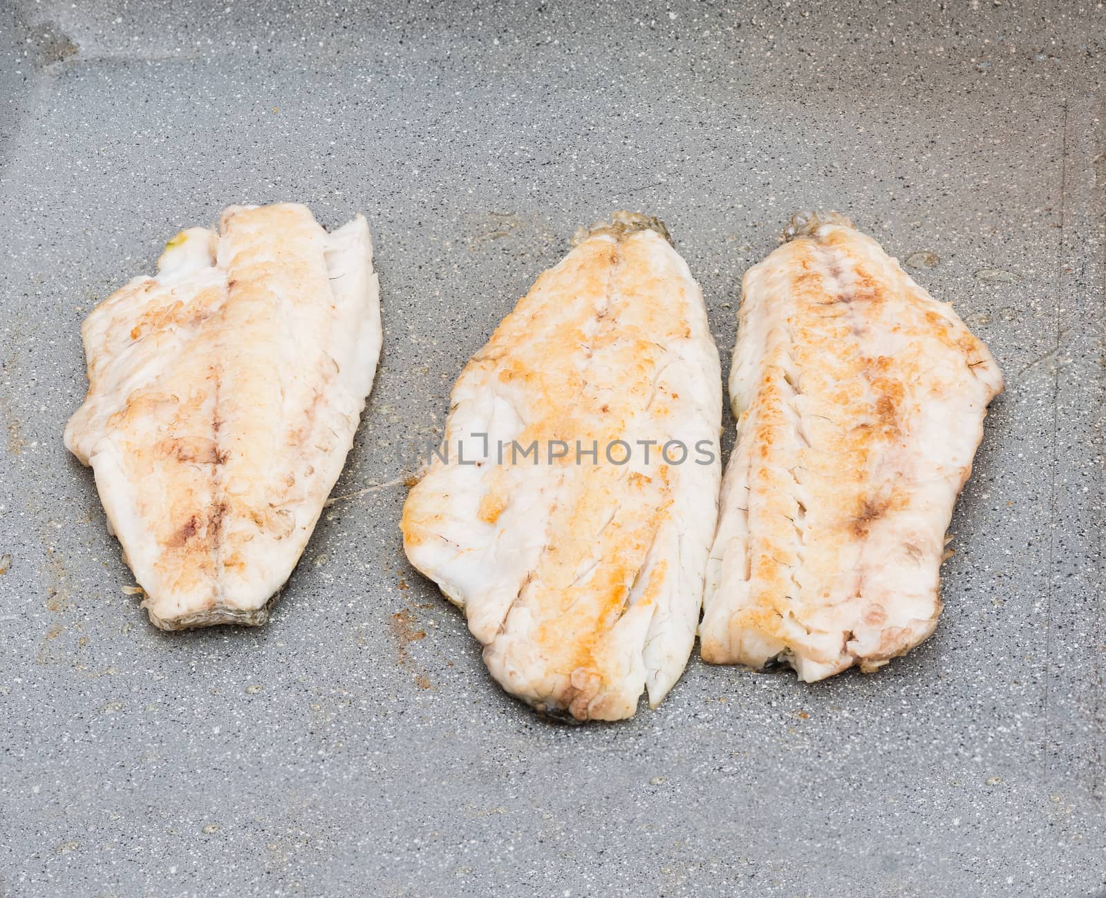Pictured three fillets of sea bream cooked on the grill