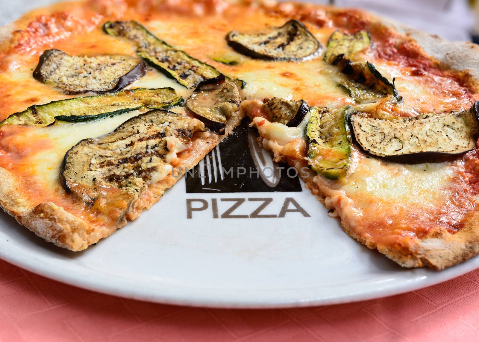 In the picture a whole wheat pizza with eggplant , zucchini , tomato and Neapolitan buffalo mozzarella.( Bufala campana)